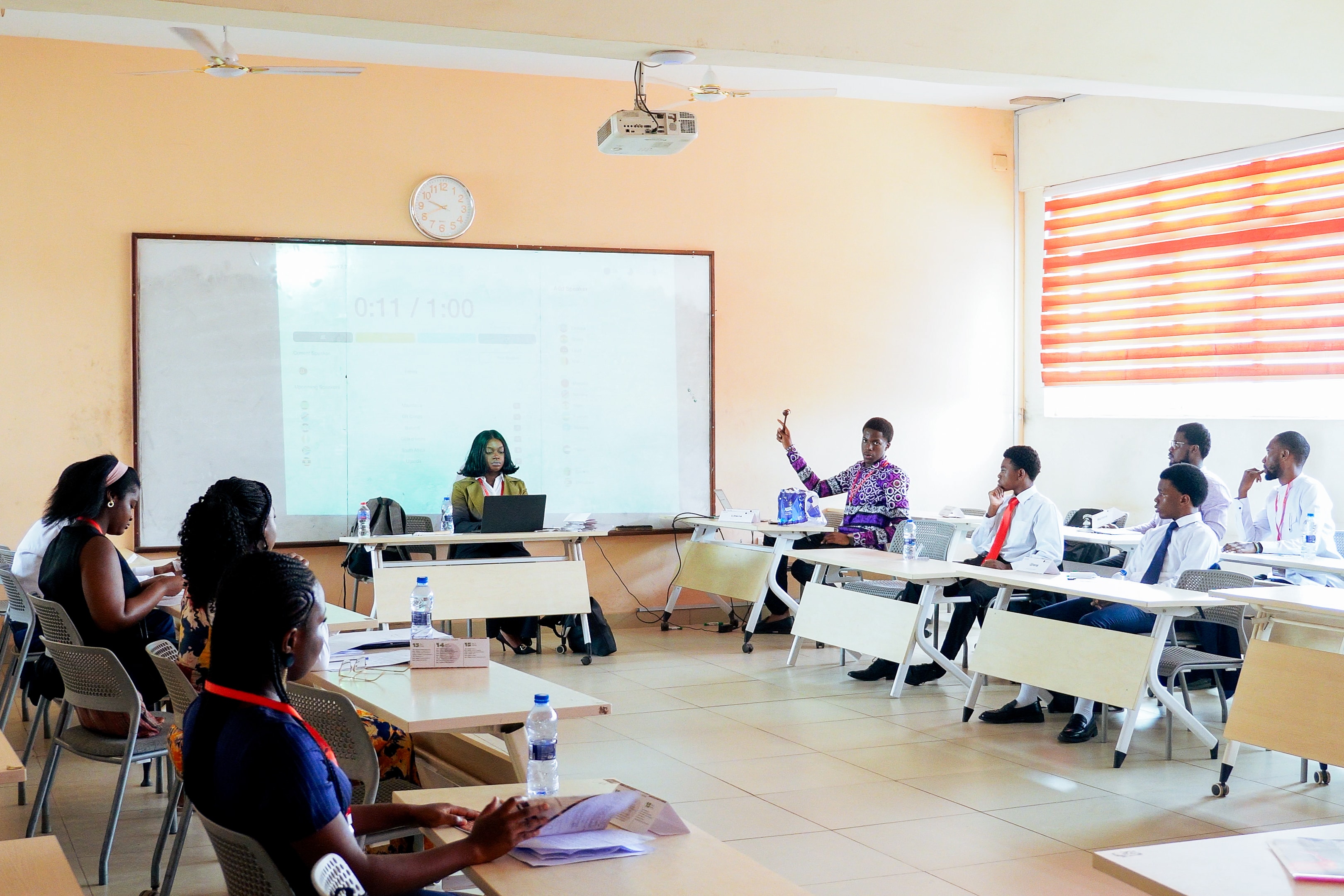 YMAU V delegates debating across a committee room
